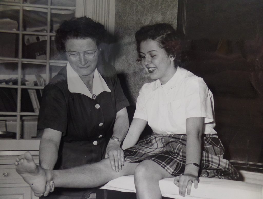 Image shows Edna Schreiber performing physical therapy with a young girl