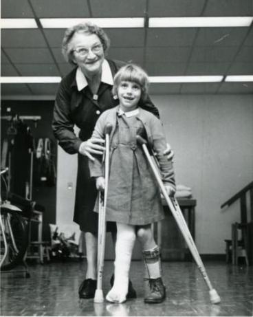 Image of Edna Schreier and a young girl on crutches doing physical therapy exercises. 