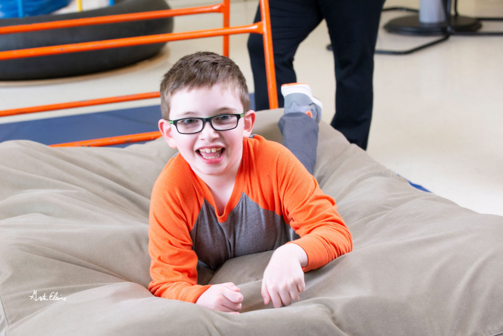 Young boy smiles at the camera during a behavioral health therapy session