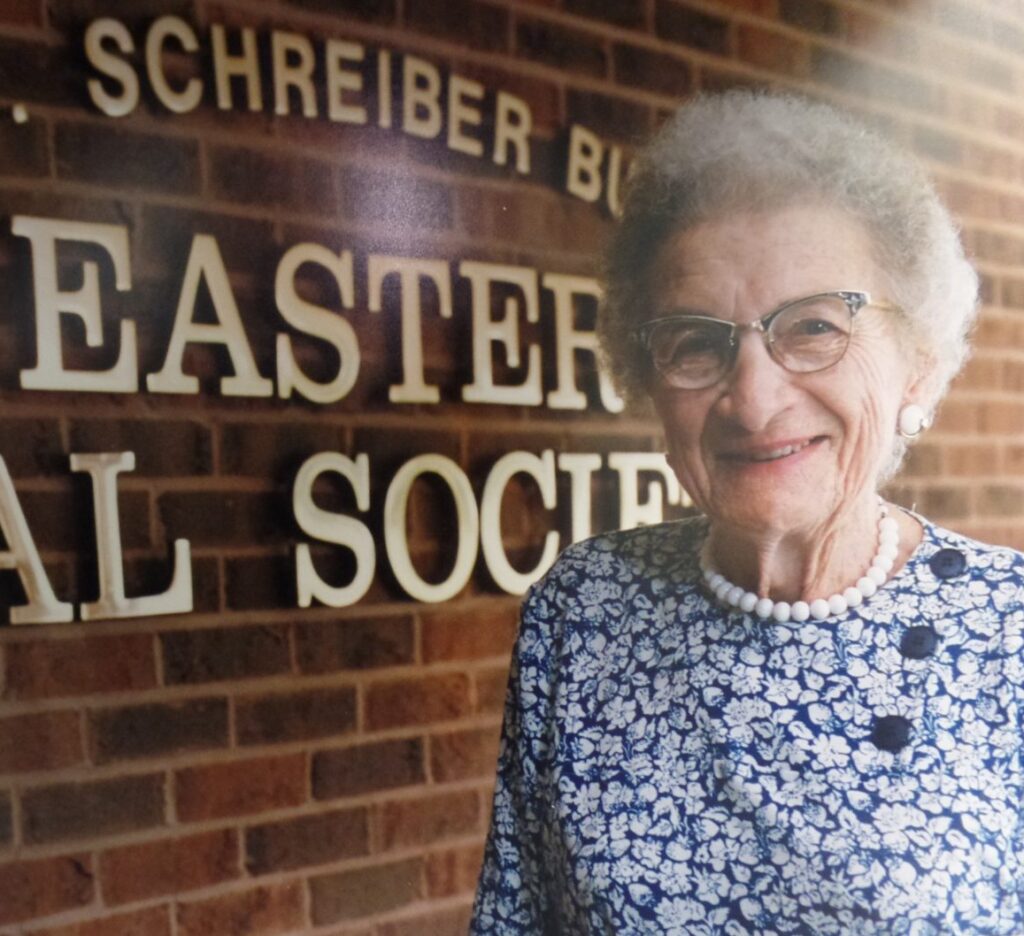 Woman in front of Schreiber Easter Seal Society sign.