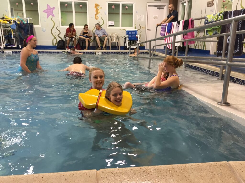 Children and therapists in pool.