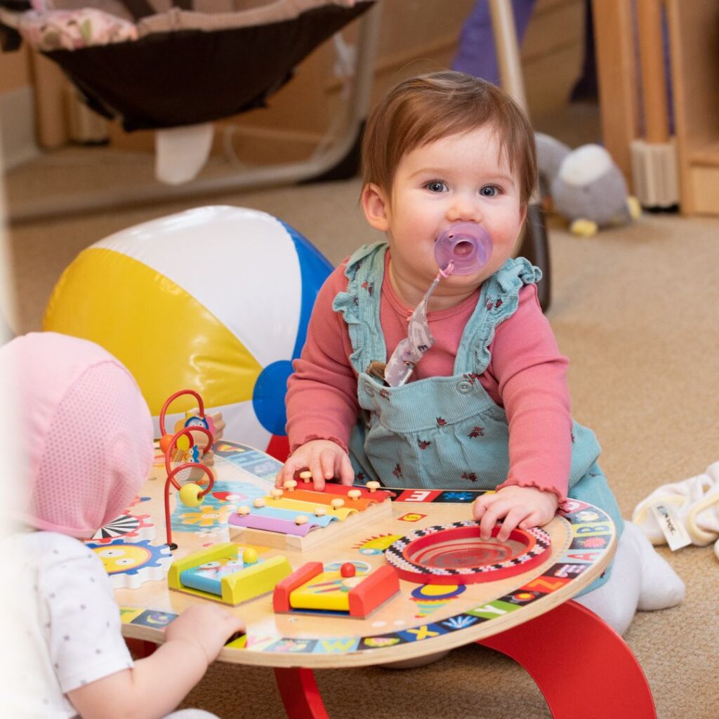 baby girl leaning on play table