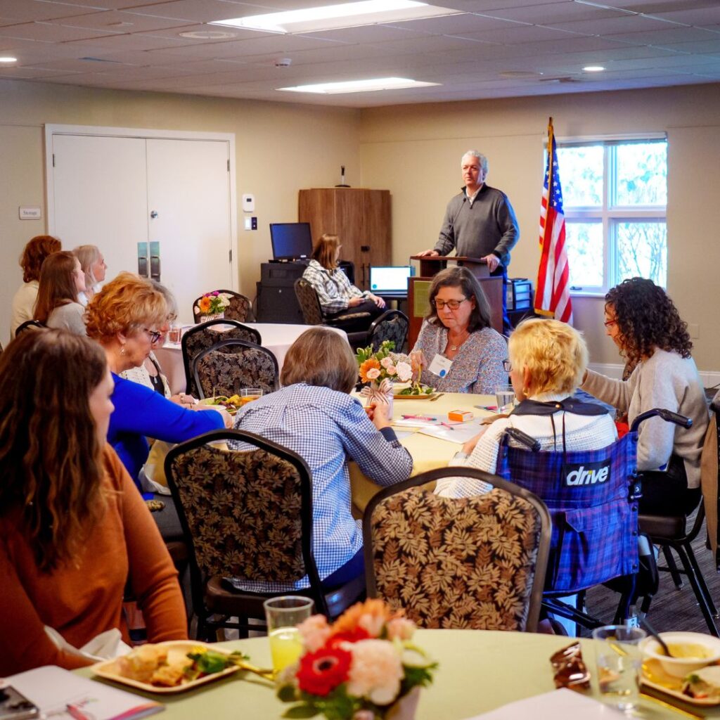 Schreiber president speaking in front of the Edna's Angels members during the annual luncheon