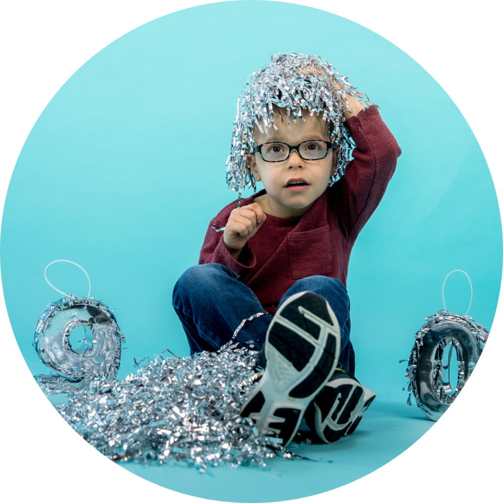 young boy sitting on the ground with a silver 