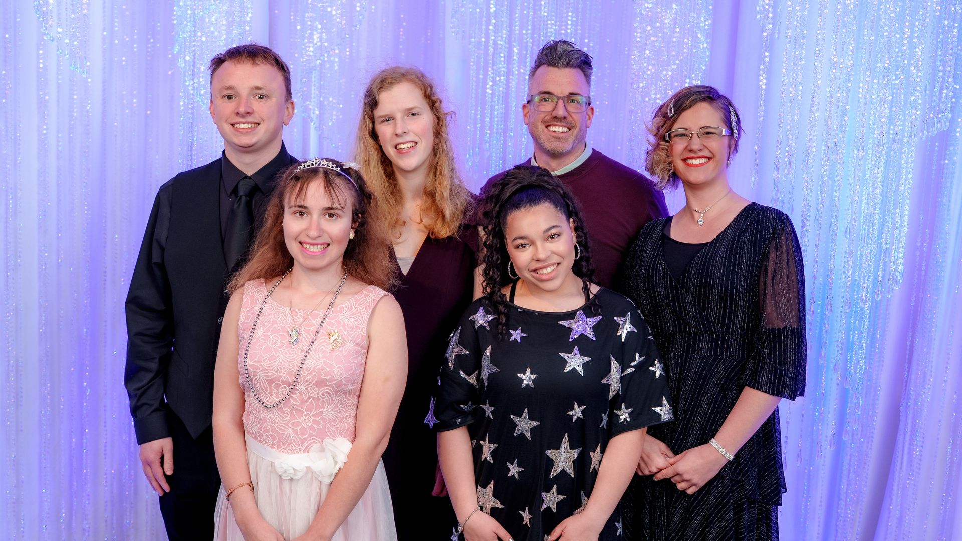 two males and 4 females dressed up and posing for a band photo