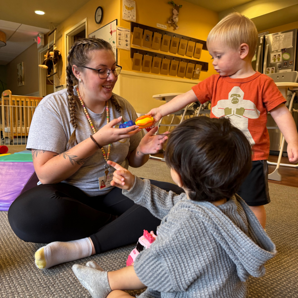 two young kids playing with teacher