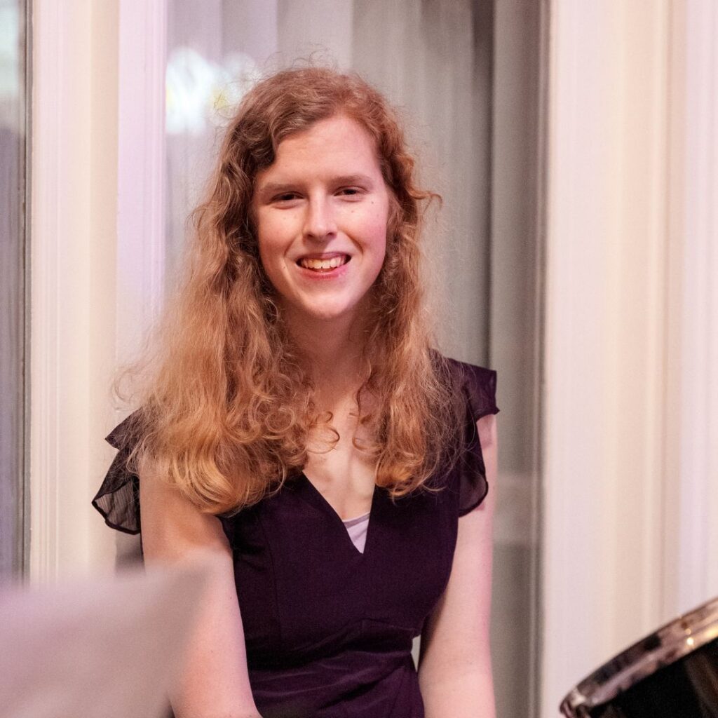 young woman with hair down smiling at the camera