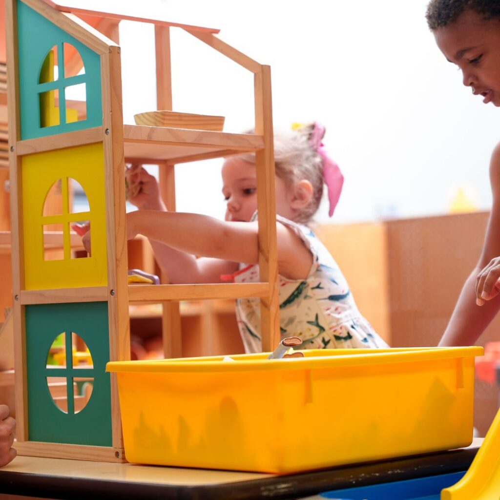Young girl playing with dollhouse