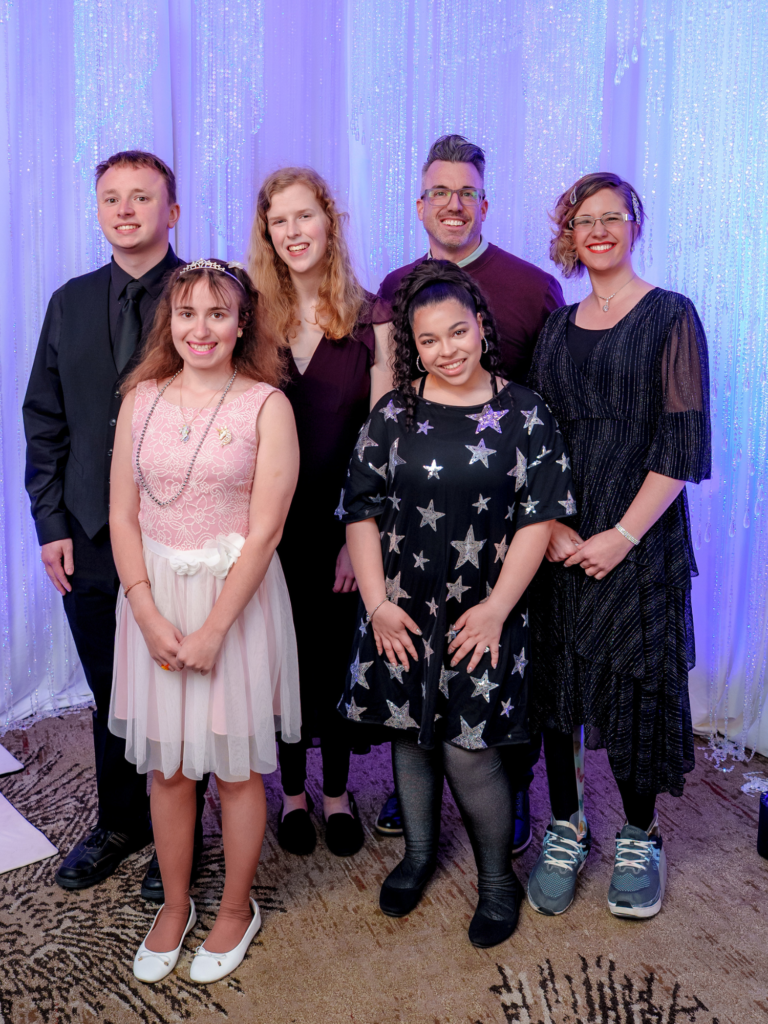 two males and 4 females dressed up and posing for a band photo