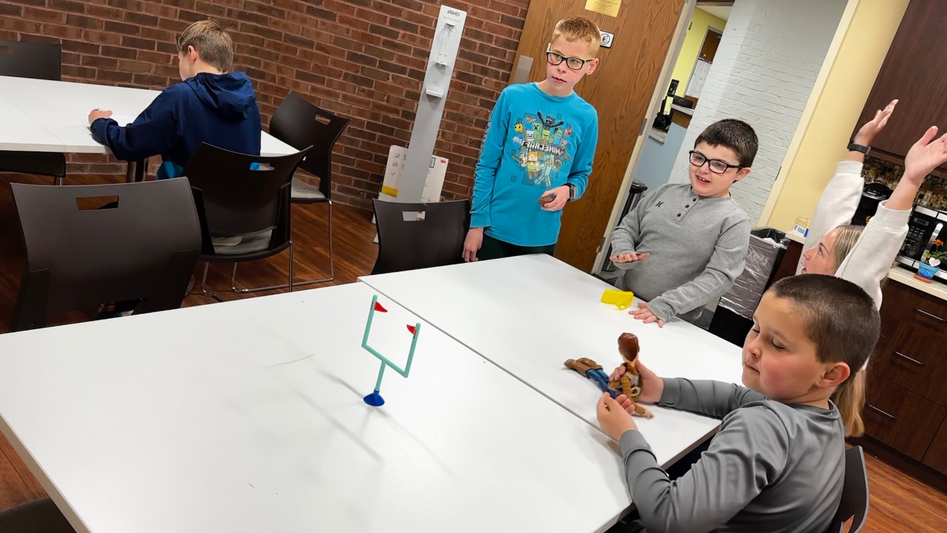 Group of boys playing paper football at a table