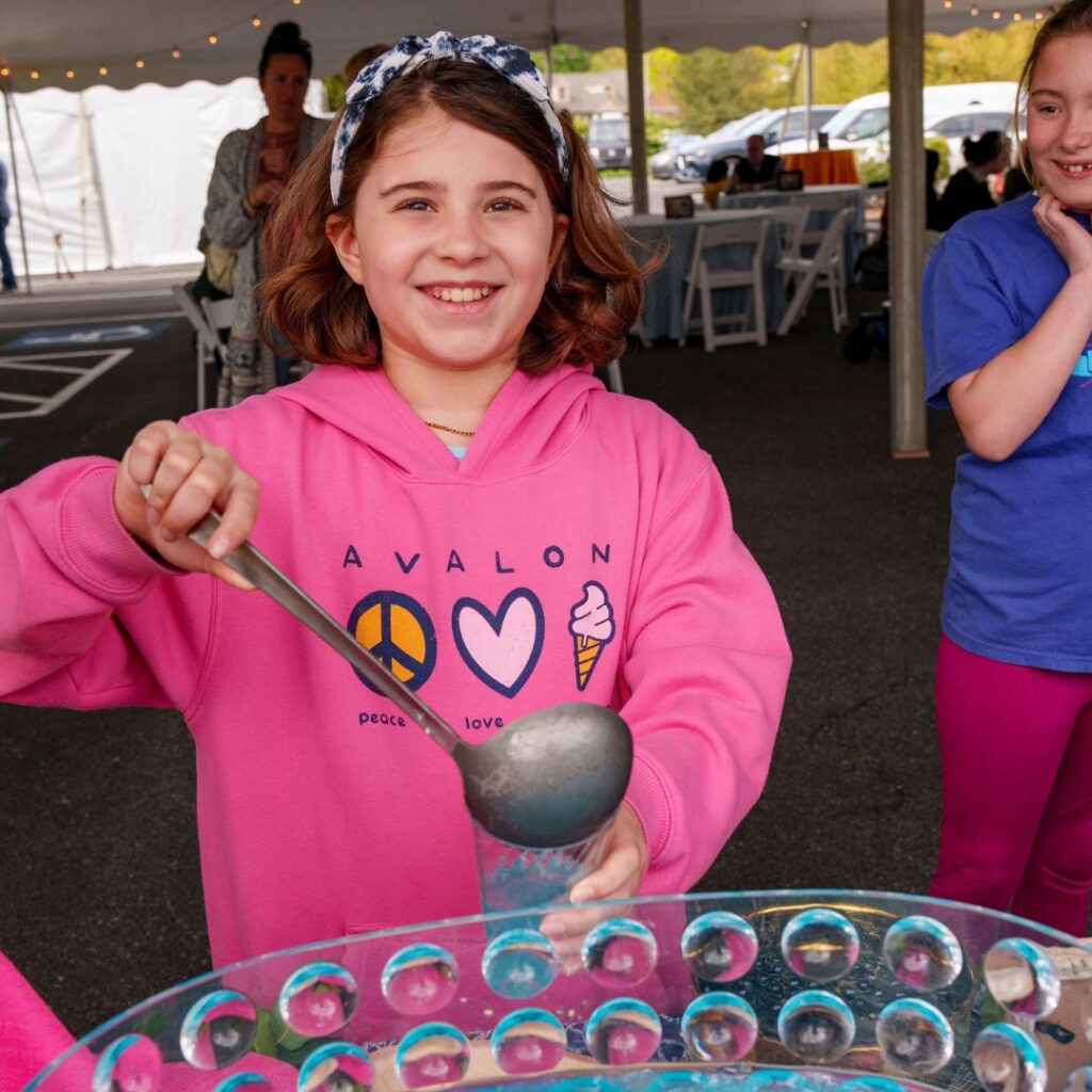 Young girl pouring punch into a cup